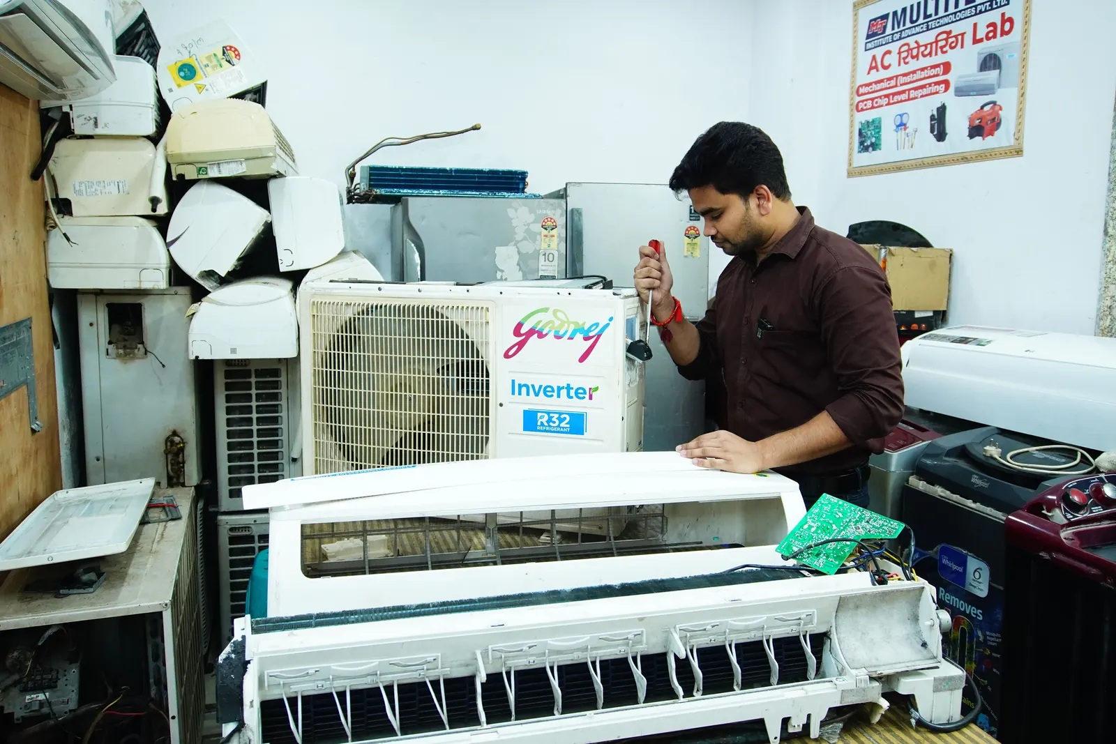 Technician servicing AC components in workshop