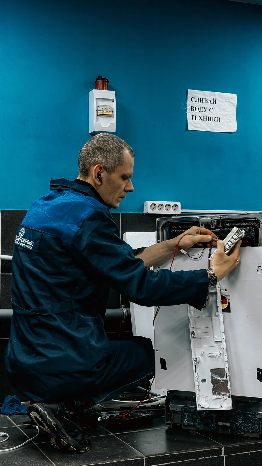 Technician inspecting appliance electronics